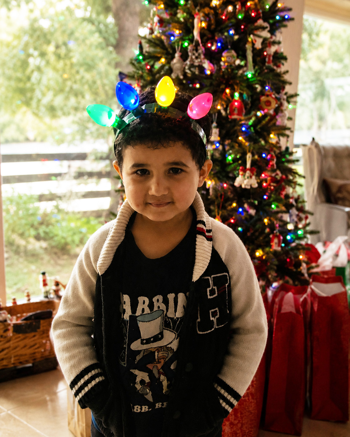 Child enjoying Christmas beside a decorated Christmas tree